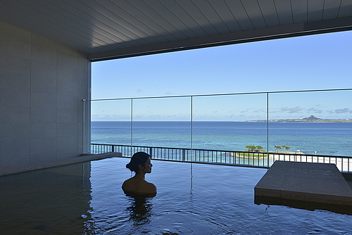 エメラルドグリーンの海と水平線にそびえる伊江島のとっておきの景色を眺めながら天然温泉に癒される。(有料)