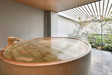 ヒバの香りが広がる木製風呂。日本庭園を眺めながらリラックスしていただけます。