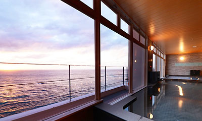 西海岸のエメラルドの海が一面に広がる展望浴場。ゆったりとお湯につかりながらサンセットの景色をお楽しみください。